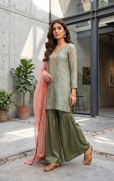 Three piece Pakistani ensemble with earthy tones and delicate hand embellished accent. Silk Gharara and shirt with net dupatta